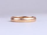 a close up of a gold wedding ring on a white background