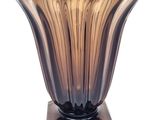 a glass vase with a wooden base on a white background