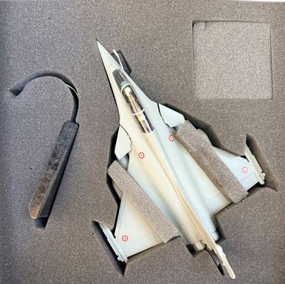 une petite maquette d'avion de chasse dans une vitrine