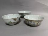 three bowls with designs of birds and flowers on them on a table
