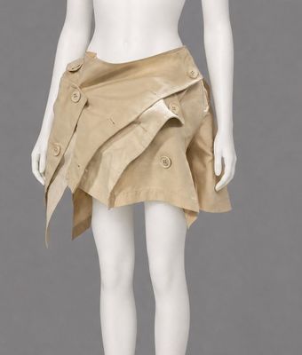 a mannequin wearing a tan skirt with buttons and a white top