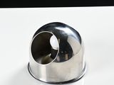 a silver object on a white surface with a black background
