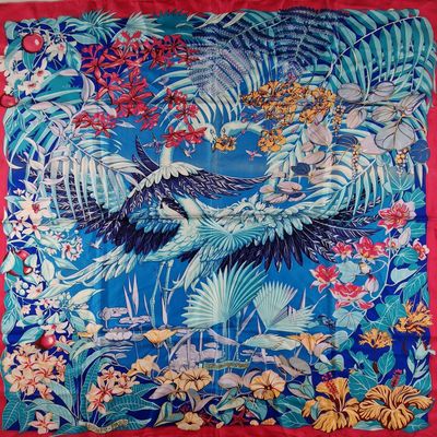 une image représentant une écharpe bleue et rouge ornée d'oiseaux et de fleurs