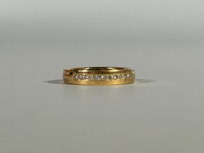 a close up of a gold ring with diamonds on a table