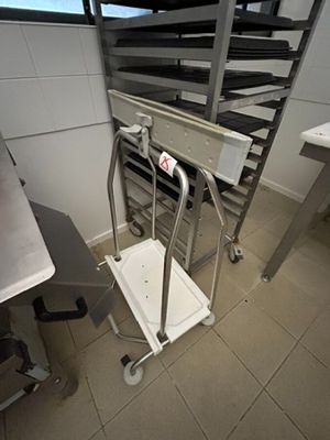 une cuisine avec un chariot métallique au milieu de la pièce