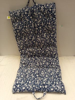 le dos d'un coussin de chaise à motifs floraux bleus et blancs posé sur une surface blanche