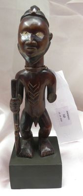 statue d'un homme tenant un bâton à la main, posée sur un socle noir