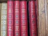 de nombreux livres qui se trouvent sur une étagère dans la pièce