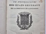 un livre ouvert sur lequel figure un blason