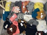 une boîte remplie de pulls et d'écharpes posée par terre