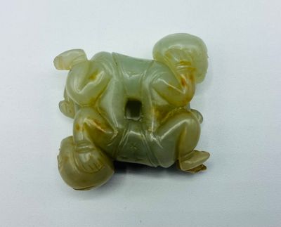 une photo d'une figurine d'éléphant verte et jaune posée sur une surface blanche
