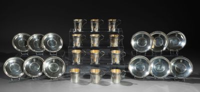 beaucoup de tasses et de soucoupes en argent posées sur une table