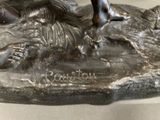 a bronze statue of a man riding a horse on a rock