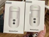 someone holding two boxes of motioncam and a bottle of medicine