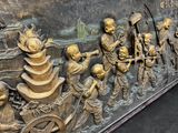 a large bronze sculpture of a group of people on a boat