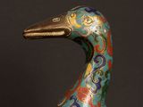 a close up of a colorful bird statue on a black surface
