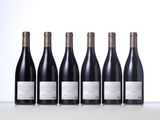six bottles of wine lined up in a row on a table