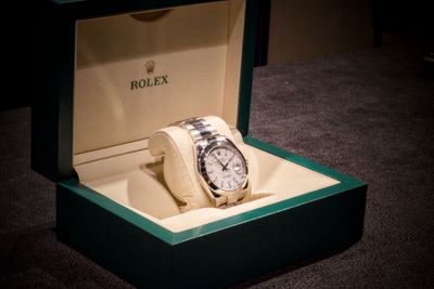 une montre Rolex posée dans une boîte par terre
