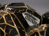 a close up of a black and gold sculpture