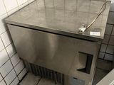 un lavabo en acier inoxydable dans un coin d'une salle de bains carrelée