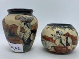 two vases with asian designs on them sitting next to each other