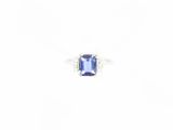 a close up of a ring with a blue stone on a white background