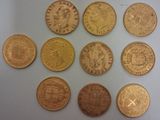 six types différents de pièces d'or sur une surface blanche