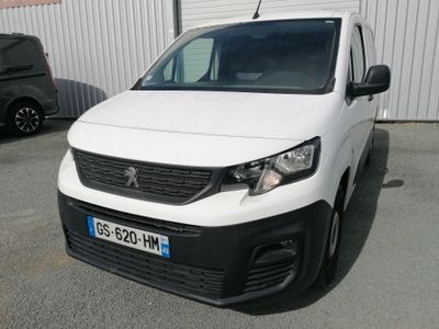 La camionnette blanche est garée devant un bâtiment blanc.