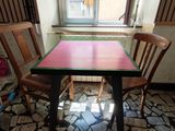 a table and two chairs in a room with a window