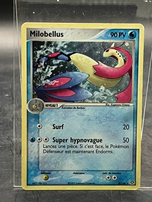 une carte Pokémon dans un étui en plastique posé sur une table