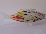 a glass fish that is sitting on a white surface