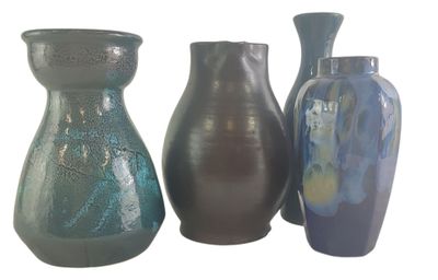 trois vases posés l'un à côté de l'autre sur une surface blanche