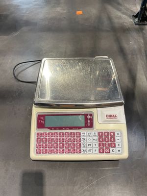 une balance posée sur une table, avec un clavier rouge dessus