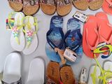 many pairs of sandals that are on a table