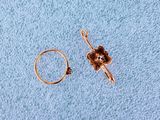 a gold ring with a flower on it next to a gold ring with a flower on it