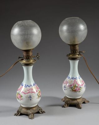 pair of antique glass lamps with floral designs on them on a gray background
