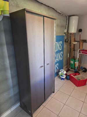 une photo d'une pièce avec un réfrigérateur et une poubelle