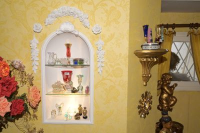 un vase de fleurs posé sur une étagère dans un coin de la pièce