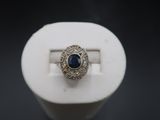 a close up of a ring with a blue stone in it