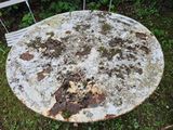 an old pizza sitting on top of a table in the grass