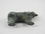 an old bronze figurine of a dog on a white surface