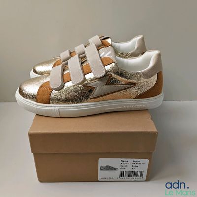 un gros plan sur une paire de chaussures posée sur une boîte