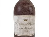 an old bottle of wine sitting on top of a white surface