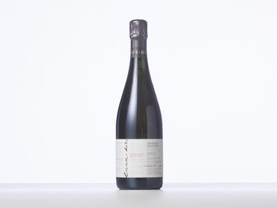 une bouteille de vin posée sur une table blanche