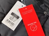 a close up of a black jacket with a red tag on it