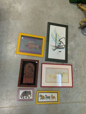 many framed pictures on the floor of this room