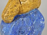 a sculpture of a person sitting on top of a rock