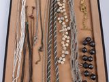 many different necklaces and bracelets displayed in a box