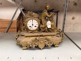 a gold clock sitting on a shelf in a room