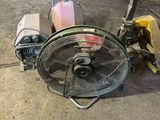 un ventilateur posé par terre à côté d'un chariot